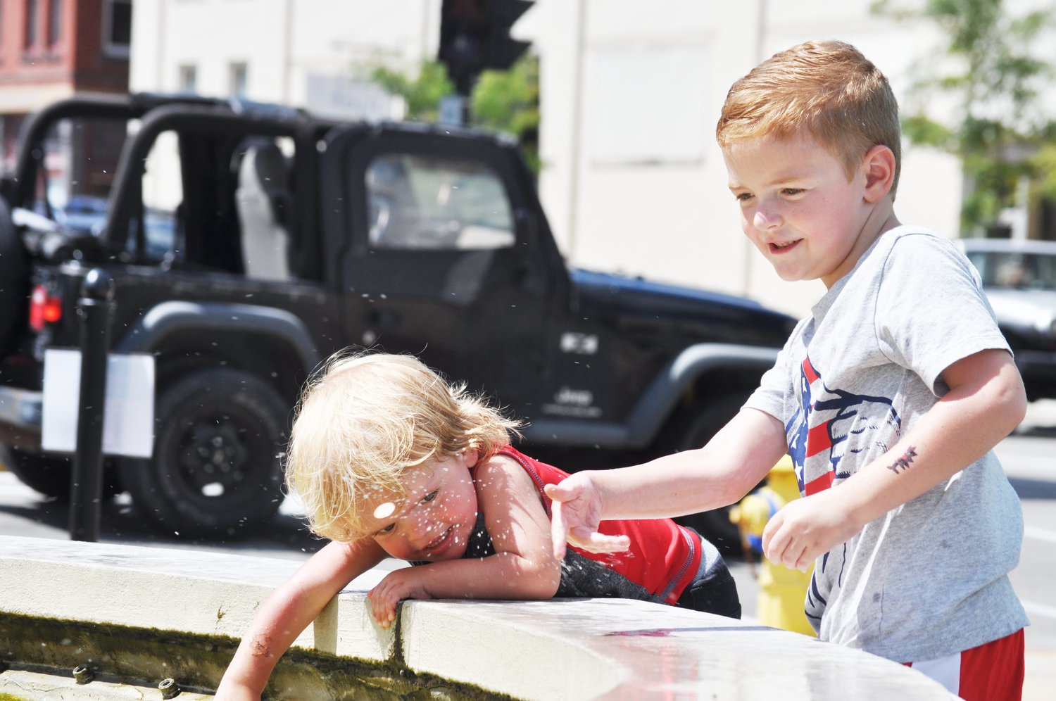 Aden Beck, 6, right, and his brother, Mathis, 2, play in the fountain at Marie Canine Plaza during Lunch on the Plaza 2.0 Friday.